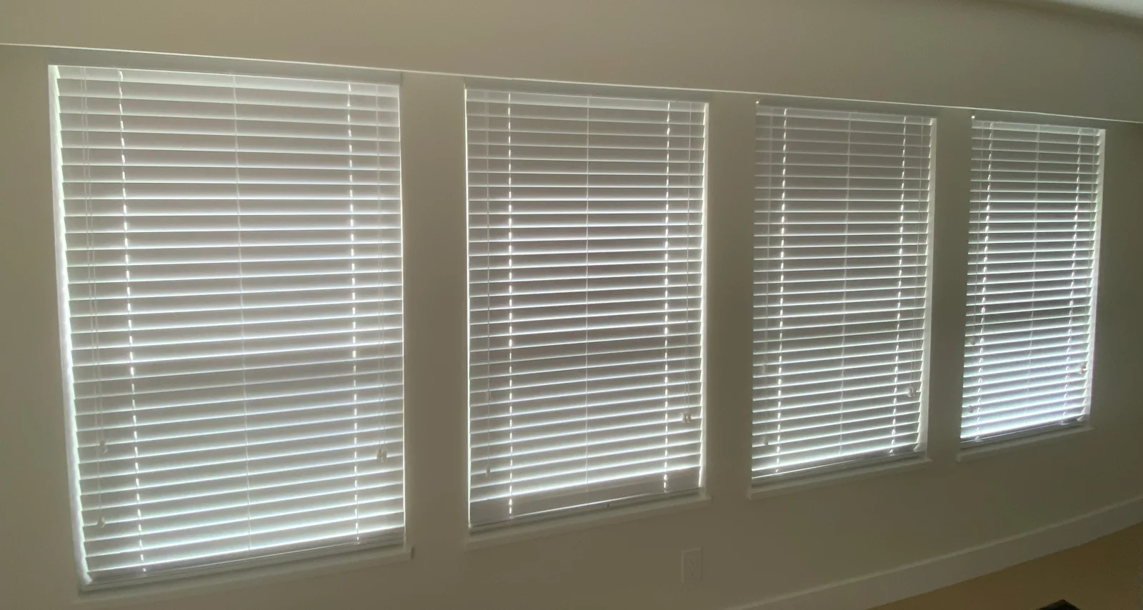 Matching faux wood blinds across four windows